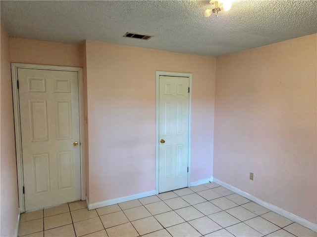 126 Boardwalk St, La Place, LA 70068 - unfurnished bedroom with light tile patterned flooring, a textured ceiling, baseboards, and a closet