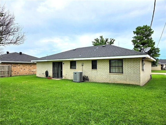 126 Boardwalk St, La Place, LA 70068 - back of property with brick siding, a shingled roof, and central air condition unit