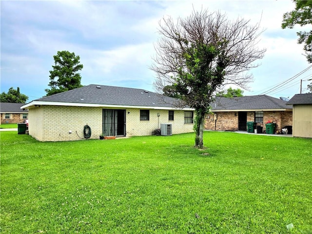 126 Boardwalk St, La Place, LA 70068 - rear view of house with brick siding, a yard, and central AC
