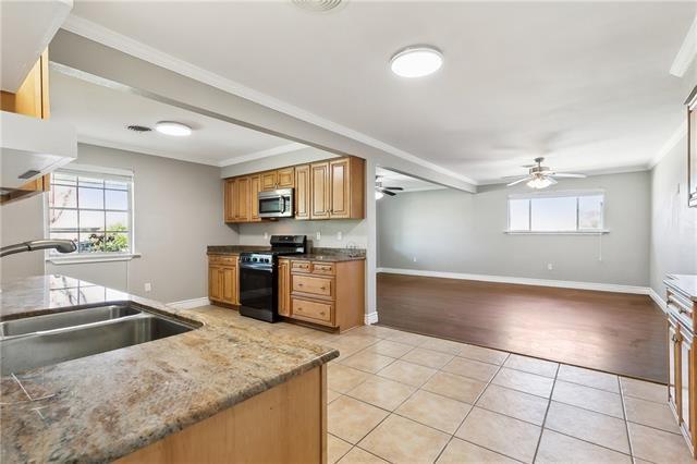 4804 Antonini Dr, Metairie, LA 70006 - kitchen with appliances with stainless steel finishes, a sink, ceiling fan, light tile patterned floors, and baseboards