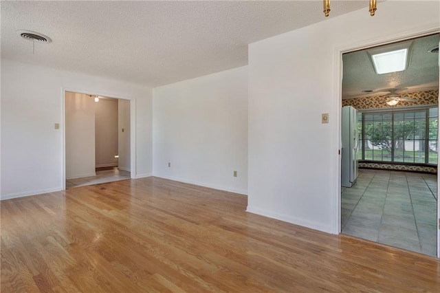 1569 Maplewood Dr, Slidell, LA 70458 - empty room with light wood-style floors, a textured ceiling, baseboards, and ceiling fan