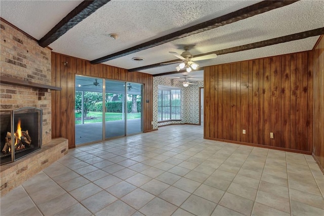 1569 Maplewood Dr, Slidell, LA 70458 - unfurnished living room featuring a textured ceiling, beam ceiling, wood walls, ceiling fan, and light tile patterned flooring