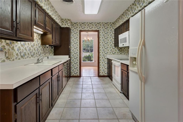 1569 Maplewood Dr, Slidell, LA 70458 - kitchen featuring white appliances, wallpapered walls, a sink, light countertops, and dark brown cabinets