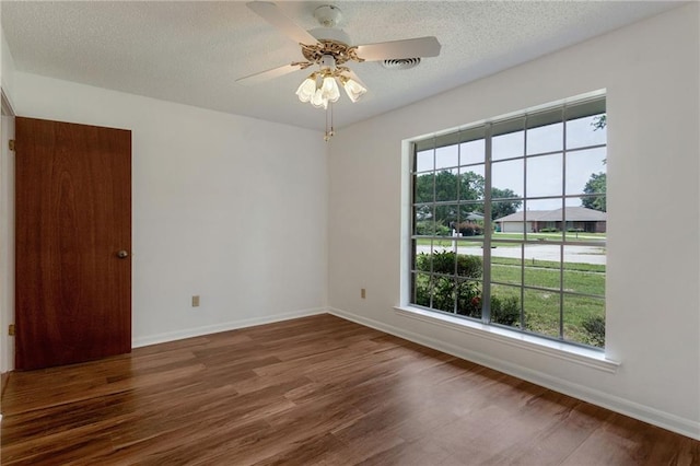 1569 Maplewood Dr, Slidell, LA 70458 - unfurnished room with plenty of natural light, wood finished floors, baseboards, and a textured ceiling