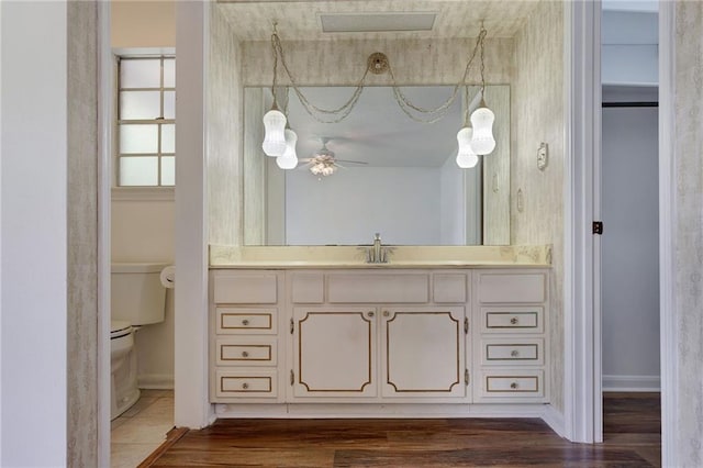 1569 Maplewood Dr, Slidell, LA 70458 - bathroom with toilet, vanity, wood finished floors, and baseboards