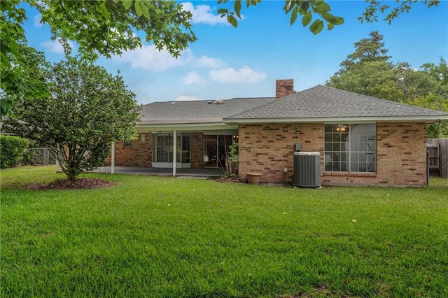 1569 Maplewood Dr, Slidell, LA 70458 - back of property featuring brick siding, a chimney, a patio area, central AC unit, and a shingled roof