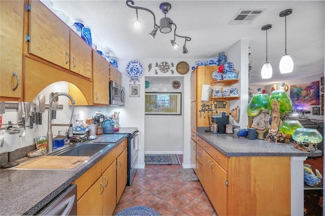 11 Richelle St, Waggaman, LA 70094 - kitchen featuring stainless steel appliances, a sink, dark countertops, brown cabinetry, and a textured ceiling