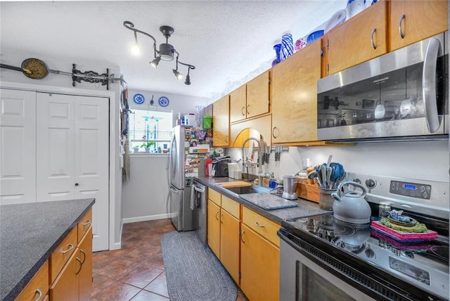 11 Richelle St, Waggaman, LA 70094 - kitchen featuring stainless steel appliances, a sink, dark countertops, dark tile patterned floors, and a textured ceiling