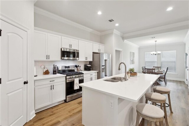 39651 Fairhope Dr, Ponchatoula, LA 70454 - kitchen featuring stainless steel appliances, a sink, crown molding, a kitchen breakfast bar, and an island with sink