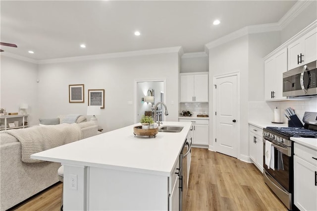 39651 Fairhope Dr, Ponchatoula, LA 70454 - kitchen with stainless steel appliances, a sink, open floor plan, decorative backsplash, and light wood-type flooring