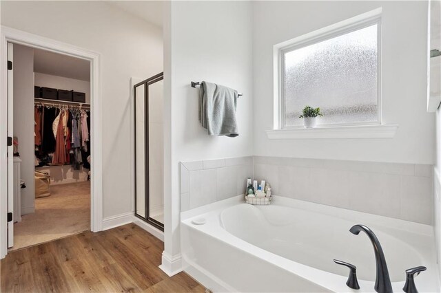 39651 Fairhope Dr, Ponchatoula, LA 70454 - full bathroom featuring a bath, a shower stall, wood finished floors, and a spacious closet