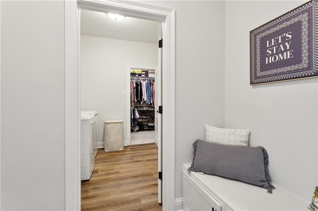 39651 Fairhope Dr, Ponchatoula, LA 70454 - hallway featuring separate washer and dryer, light wood-type flooring, and baseboards