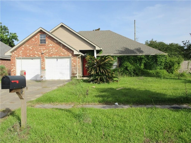 2 Tuscany Dr, La Place, LA 70068 - view of front of home featuring a front yard, an attached garage, brick siding, and driveway