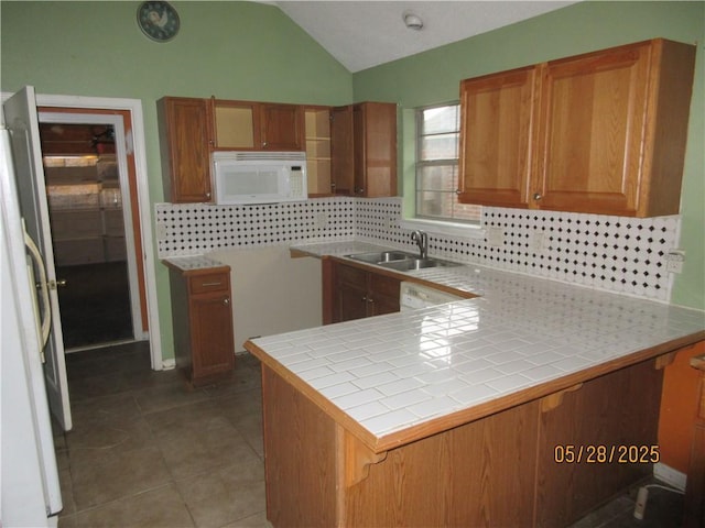 2 Tuscany Dr, La Place, LA 70068 - kitchen with white appliances, vaulted ceiling, a peninsula, backsplash, and a sink