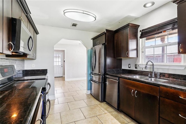 3405 Moss Ln, Violet, LA 70092 - kitchen with stainless steel appliances, plenty of natural light, arched walkways, and light tile patterned floors