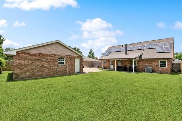3405 Moss Ln, Violet, LA 70092 - rear view of house with brick siding, a patio, roof mounted solar panels, roof with shingles, and central AC