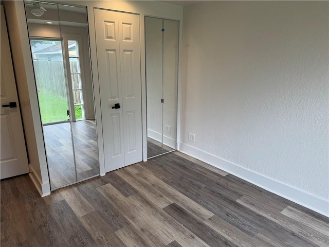 1005 David Dr, Metairie, LA 70003 - unfurnished bedroom featuring dark wood finished floors and multiple closets
