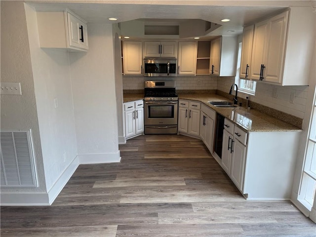 1005 David Dr, Metairie, LA 70003 - kitchen featuring stainless steel appliances, tasteful backsplash, wood finished floors, plenty of natural light, and recessed lighting