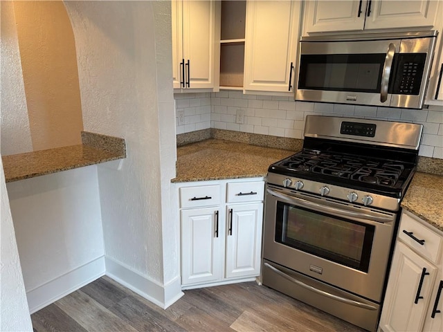 1005 David Dr, Metairie, LA 70003 - kitchen with appliances with stainless steel finishes, dark wood-style floors, decorative backsplash, open shelves, and a textured wall