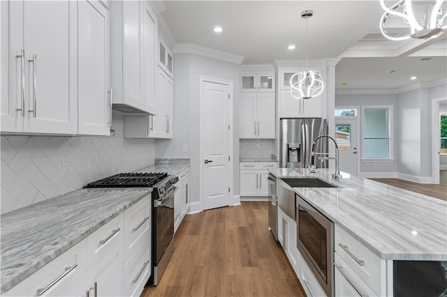 1208 Lucille Ave, Metairie, LA 70003 - kitchen with appliances with stainless steel finishes, a chandelier, ornamental molding, a center island with sink, and a sink
