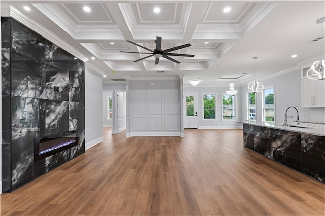 1208 Lucille Ave, Metairie, LA 70003 - living room with wood finished floors, a ceiling fan, a tiled fireplace, ornamental molding, and coffered ceiling