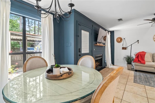 120 W Pineridge St Unit 120, Mandeville, LA 70448 - dining space featuring a chandelier, a ceiling fan, light tile patterned flooring, and a warm lit fireplace