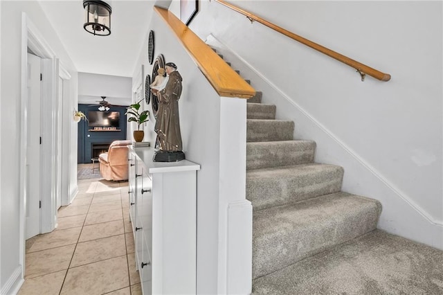 120 W Pineridge St Unit 120, Mandeville, LA 70448 - staircase featuring a warm lit fireplace, tile patterned flooring, and a ceiling fan