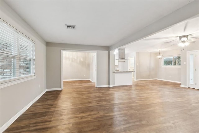 4509 Purdue Dr, Metairie, LA 70003 - unfurnished living room featuring wood finished floors, baseboards, a ceiling fan, and a chandelier