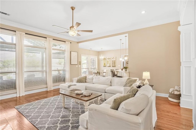 1067 Scarlet Oak Ln, Mandeville, LA 70448 - living room with a ceiling fan, crown molding, light wood-style floors, baseboards, and a chandelier