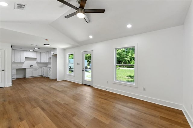 35210 Windsor Dr, Slidell, LA 70460 - unfurnished living room with a sink, a ceiling fan, vaulted ceiling, light wood-style flooring, and baseboards