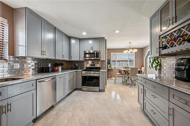 3816 Jean Lafitte Pkwy, Chalmette, LA 70043 - kitchen with appliances with stainless steel finishes, gray cabinetry, tasteful backsplash, light stone countertops, and recessed lighting