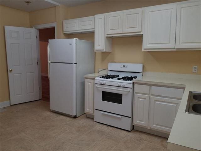 2607 Soniat St, New Orleans, LA 70115 - kitchen featuring white appliances, light countertops, and white cabinets