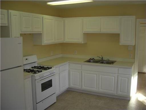2607 Soniat St, New Orleans, LA 70115 - kitchen with white appliances, white cabinetry, and light countertops