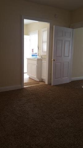2607 Soniat St, New Orleans, LA 70115 - carpeted spare room featuring baseboards and a sink