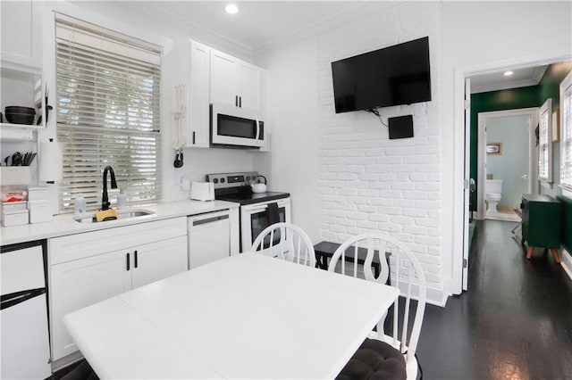 1030 Kerlerec St Unit 6, New Orleans, LA 70116 - kitchen with white appliances, a sink, white cabinetry, light countertops, and dark wood finished floors