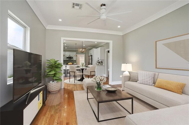 2327 Pauline St, New Orleans, LA 70117 - living area featuring light wood-type flooring, crown molding, ceiling fan, and recessed lighting