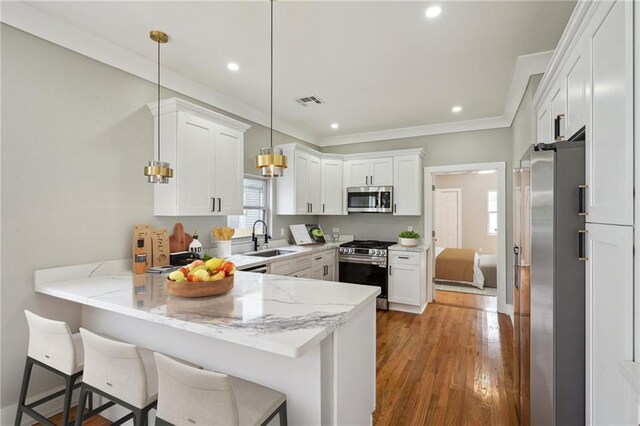 2327 Pauline St, New Orleans, LA 70117 - kitchen featuring stainless steel appliances, a peninsula, white cabinetry, light stone countertops, and crown molding