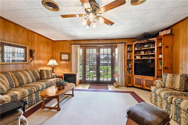 2108 Washington St, Franklinton, LA 70438 - living room featuring wooden walls, a ceiling fan, and carpet floors