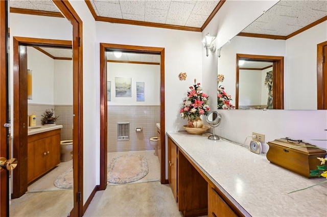 2108 Washington St, Franklinton, LA 70438 - bathroom with toilet, vanity, tile walls, ornamental molding, and wainscoting
