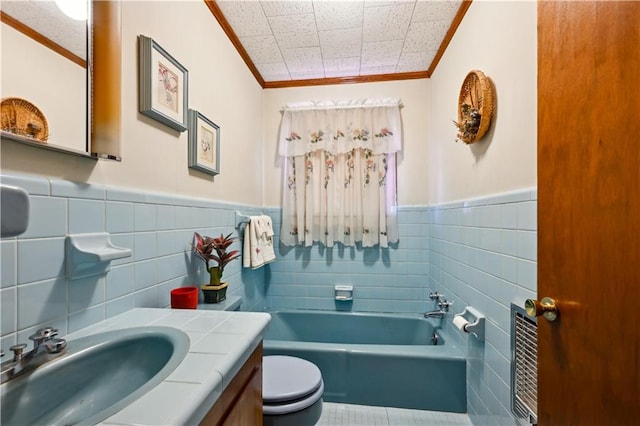 2108 Washington St, Franklinton, LA 70438 - full bath with tile walls, ornamental molding, toilet, wainscoting, and a tub