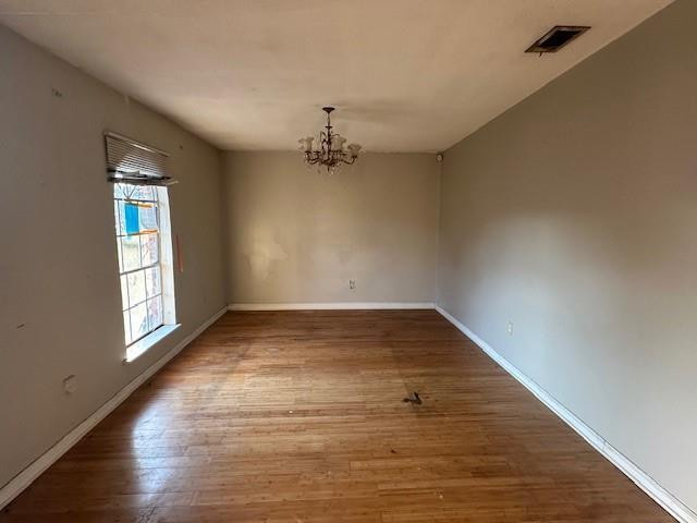 9416 Cabildo Ln, Westwego, LA 70094 - unfurnished dining area with a chandelier, wood finished floors, and baseboards