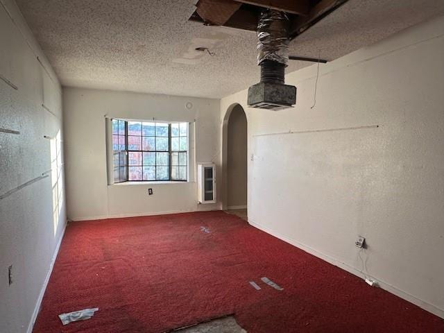 9416 Cabildo Ln, Westwego, LA 70094 - carpeted empty room featuring arched walkways, a textured ceiling, and baseboards