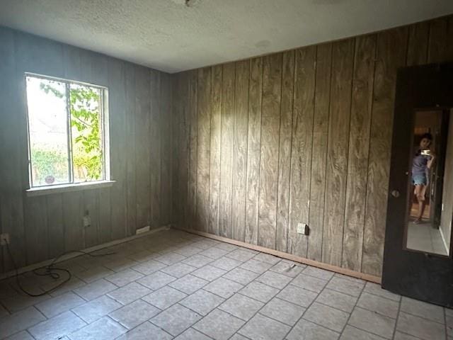 9416 Cabildo Ln, Westwego, LA 70094 - spare room with wood walls, a textured ceiling, and baseboards