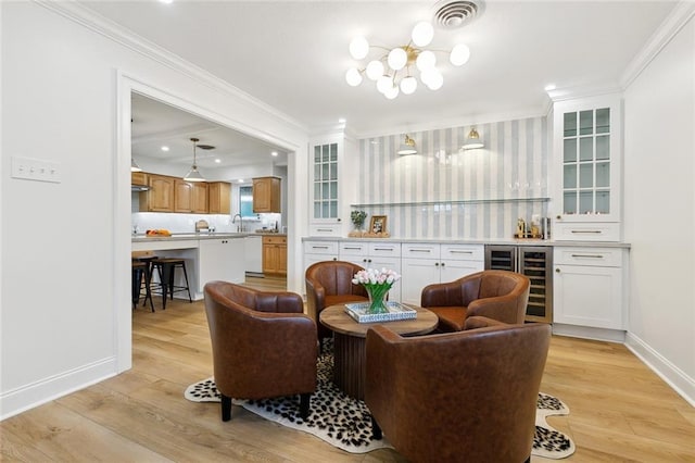 4905 Haring Ct, Metairie, LA 70006 - living area featuring wine cooler, bar area, light wood-type flooring, crown molding, and baseboards
