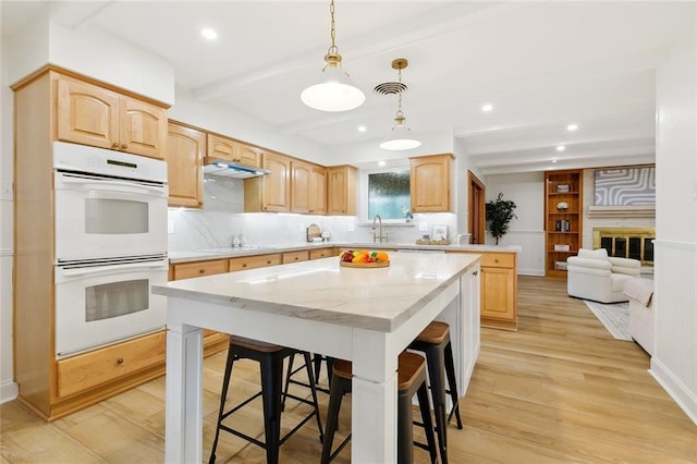 4905 Haring Ct, Metairie, LA 70006 - kitchen with double oven, a kitchen breakfast bar, a kitchen island, tasteful backsplash, and recessed lighting