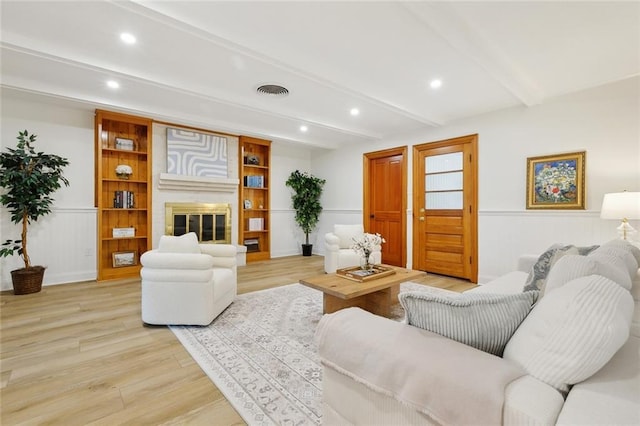 4905 Haring Ct, Metairie, LA 70006 - living room with beamed ceiling, light wood finished floors, recessed lighting, a glass covered fireplace, and wainscoting