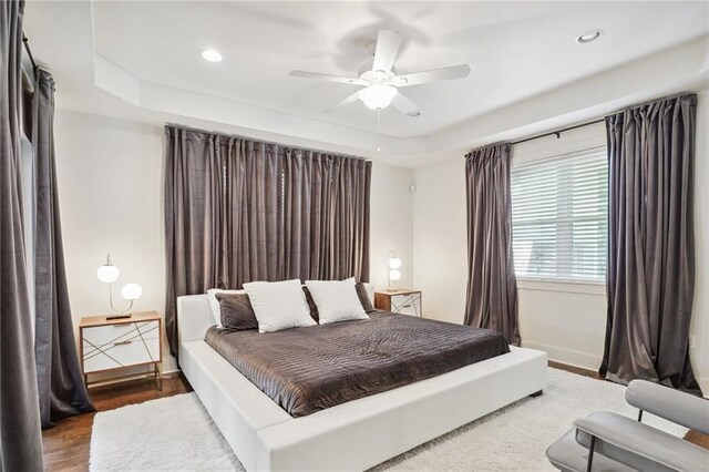 5727 Fleur De Lis Dr, New Orleans, LA 70124 - bedroom with a raised ceiling, wood finished floors, recessed lighting, baseboards, and ceiling fan