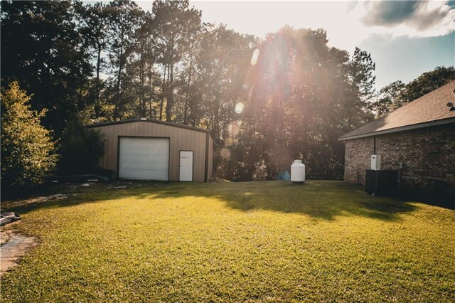 62283 Chappepeela Ridge Rd, Amite, LA 70422 - view of grassy yard with a detached garage, an outbuilding, and central air condition unit