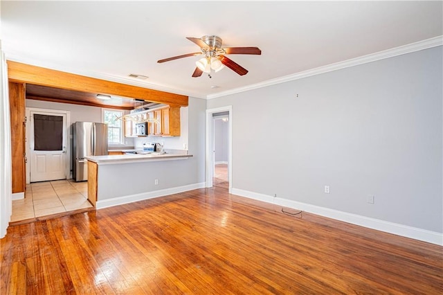 1017 Marian Ave, Metairie, LA 70001 - kitchen featuring stainless steel appliances, ceiling fan, ornamental molding, light countertops, and light wood-style flooring