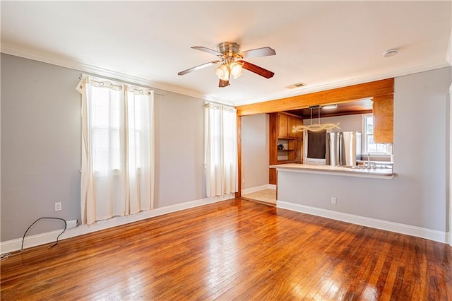 1017 Marian Ave, Metairie, LA 70001 - unfurnished living room featuring a ceiling fan, ornamental molding, hardwood / wood-style flooring, baseboards, and a sink